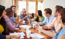 Group of people around a desk having a meeting