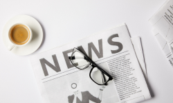 Newspaper, reading glasses and a cup of coffee